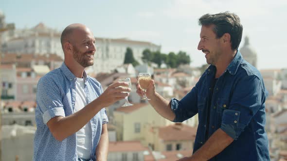 Static Shot of Cheerful Gay Couple Clinking Glasses of Champagne