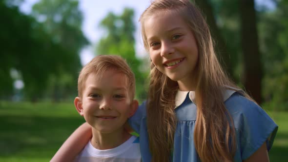 Lovely Smiling Siblings Hugging in Park