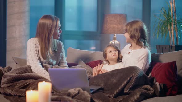 Woman and Two Girls Using Laptop While Resting on Couch