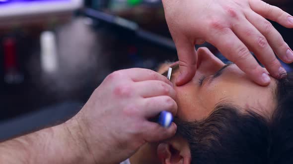 Hispanic Bearded Man Having His Hair Cut By Hairdresser at the Barbershop