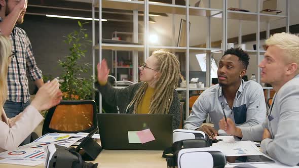 Friends Discussing Joint Project in Office Room and Greeting His Male Colleague Giving High Five