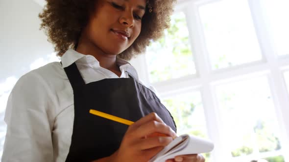 Waitress writing on notepad in restaurant