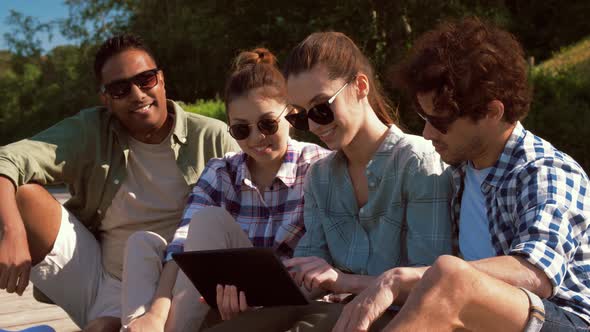 Friends with Tablet Pc on Wooden Terrace in Summer