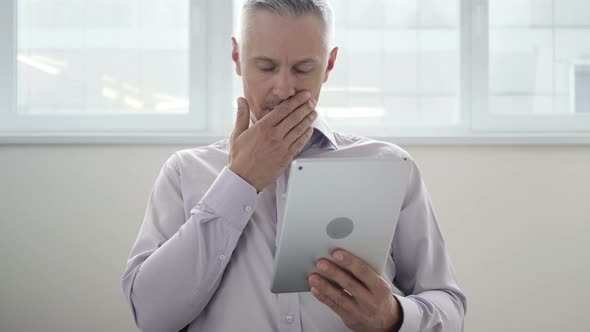 Shocked, Astonished Middle Aged Man Using Tablet