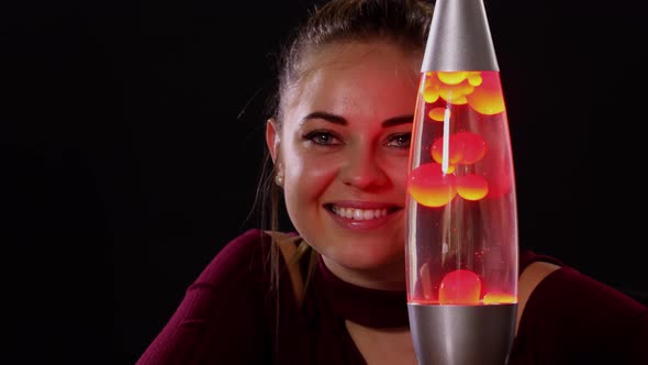 Pretty Woman Looking At A Lava Lamp
