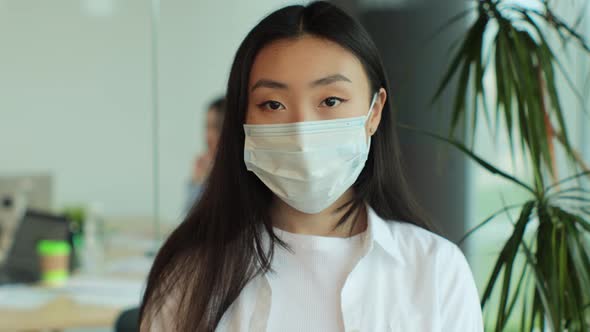 Young Asia Lady in Medical Mask Standing in Contemporary Meeting Room