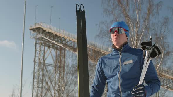 Man Carrying Skis and Poles