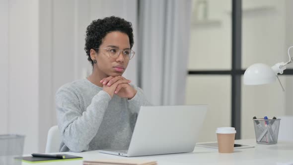 African Woman Thinking While Using Laptop