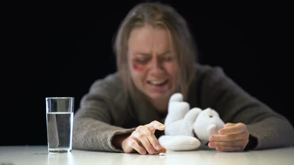 Desperate Female Hugging Stuffed Animal, Crying and Taking Painkiller, Abuse
