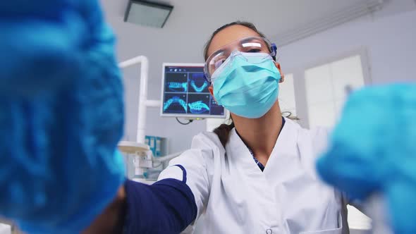 Patient Point of View to Dentist in Protective Mask Holding Tools