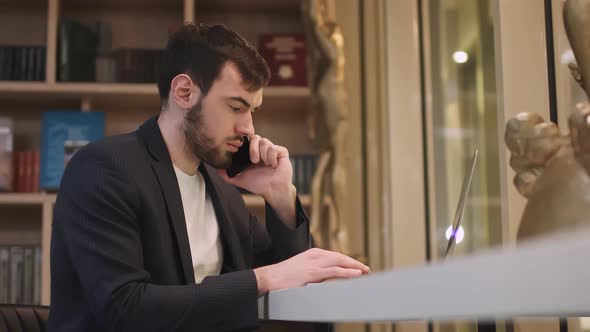 Young Focused Handsome Male Businessman Working on a Laptop