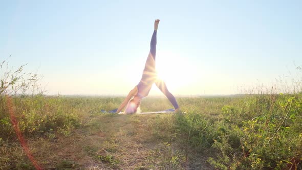 Woman Is Doing Yoga. Dawn, Green Field