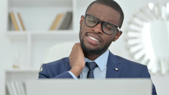 Portrait of African Businessman with Laptop Having Neck Pain