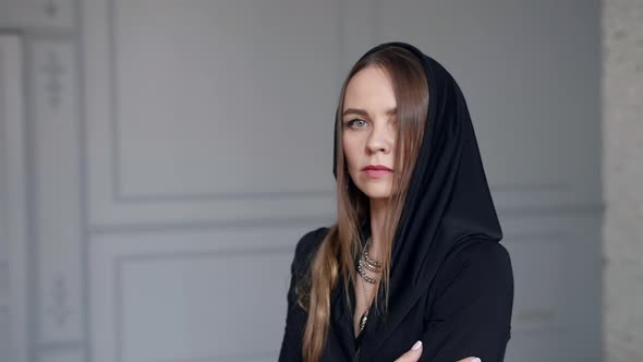 Beautiful Young Woman with Black Hood on Head Portrait in Room Dramatic Shot