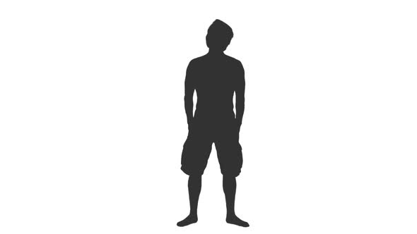 Silhouette of Man in Shorts Standing With Hands in Pockets alt
