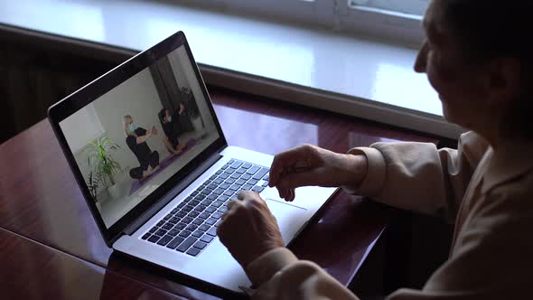 an Elderly Woman Looking at a Laptop About Covid