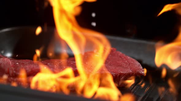 Super Slowmotion Footage of Throwing Fresh Beef Meat and Seasoning on Ignited Pan 1000Fps