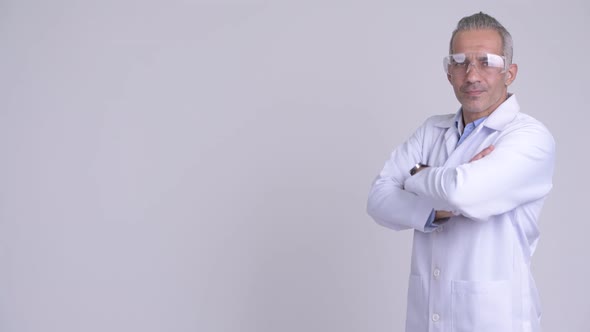 Profile View of Happy Persian Man Doctor Wearing Protective Glasses Looking at Camera