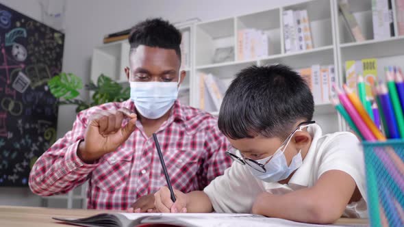 African teacher and student sitting in a room and wearing mask in private class to protect COVID19
