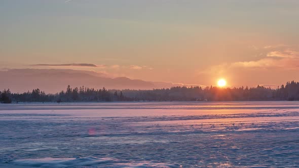 Time lapse of a frozen mountain lake during sunset. 