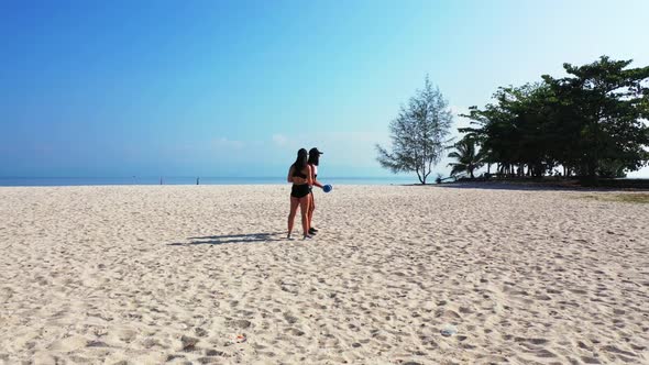 Girls happy together on tranquil shore beach wildlife by aqua blue lagoon and white sand background 