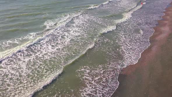 Drone view of the beautiful waves on the sandy beach,