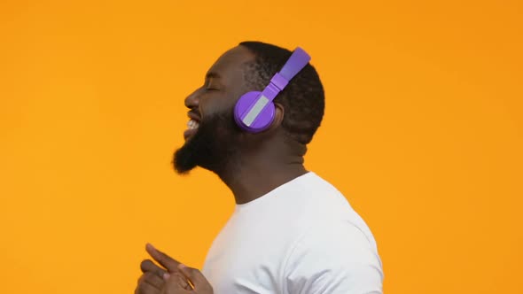 Happy Afro-American Male in Wireless Headphones Enjoying Radio Hit Dancing