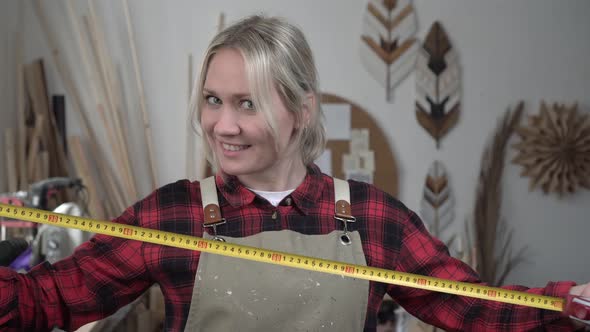 Woman in Overalls Worker with a Construction Tape Measure