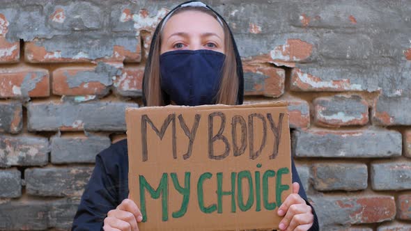 Young woman protester holds cardboard  MY BODY MY CHOICE sign Girl protesting against anti-abortion