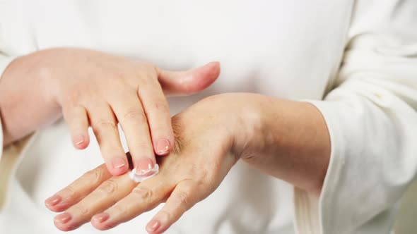 Old Woman Applying Hand Cream Closeup