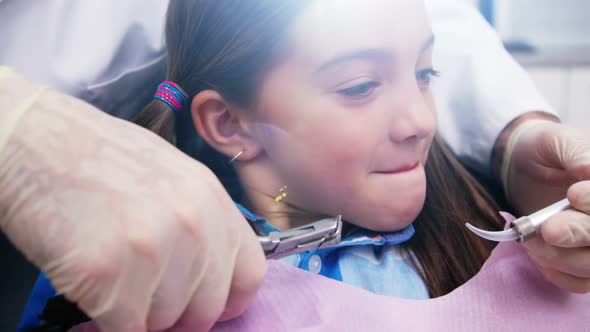 Dentist examining a young patient with tools