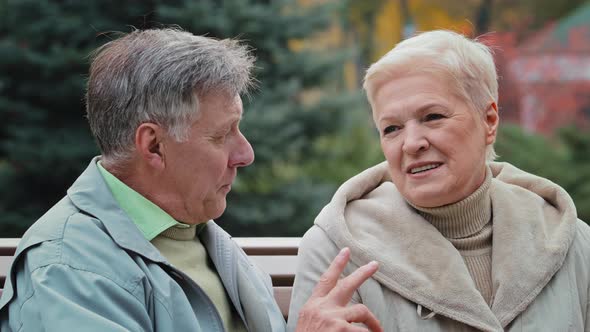 Elderly Caucasian Married Couple Lovely Grandparents Family Sitting on Bench in Autumn Park Enjoying