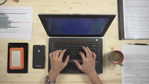 Top view of hands writing on a laptop