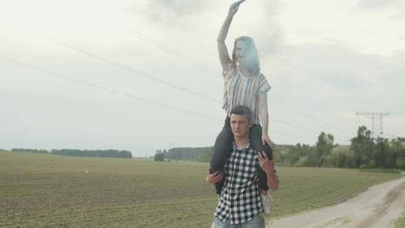 Man Carrying Woman with Smoke Bomb on Shoulders