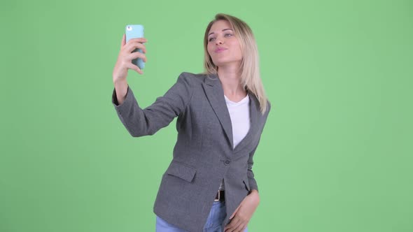 Happy Young Blonde Businesswoman Taking Selfie and Video Calling