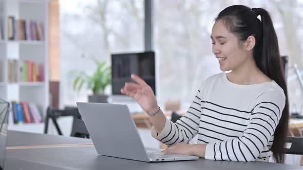 Video Chat on Laptop By Young Asian Woman in Office 
