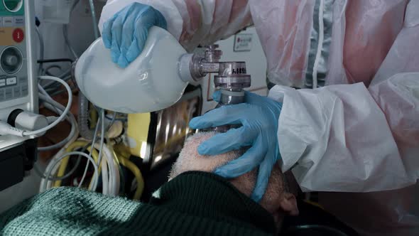 Crop Paramedic Helping Senior Patient to Breath