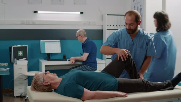 Medical Assistant Helping Old Woman with Muscles Stretching