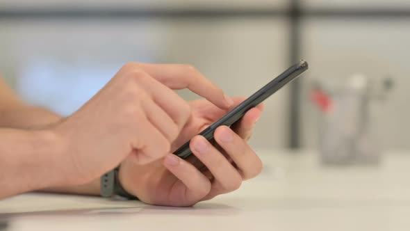 Close Up of Male Hands Using Smartphone Side View