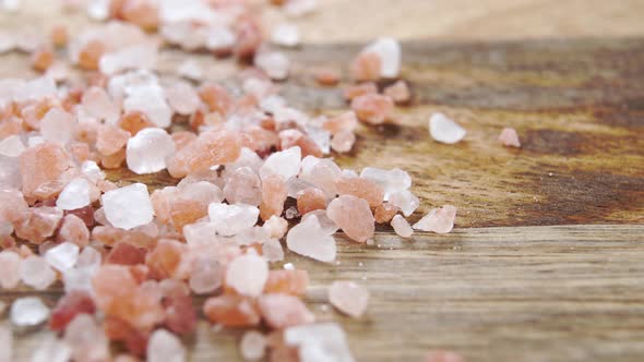 Himalayan coarse mineral seasoning salt on a rustic wooden surface. Macro