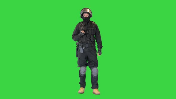 Special Forces Soldier in Black Uniform Speaking on the Radio on a Green Screen Chroma Key