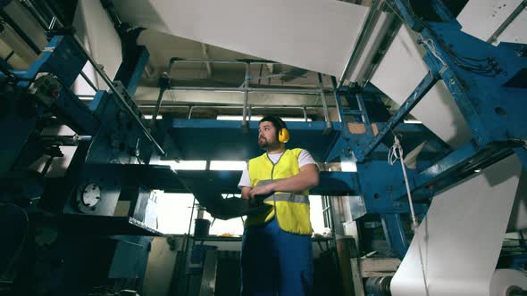 Printing Factory Worker Is Examining Functioning Equipment