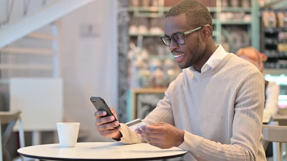 African Man Making Successful Online Payment on Smartphone 