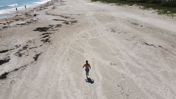 Active Lifestyle Concept - Young Man Exercising by Running on Beach