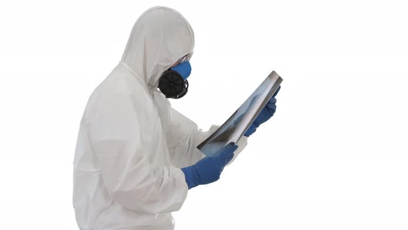 Doctor in Protective Suit Looking at Lungs X-ray While Walking on White Background.