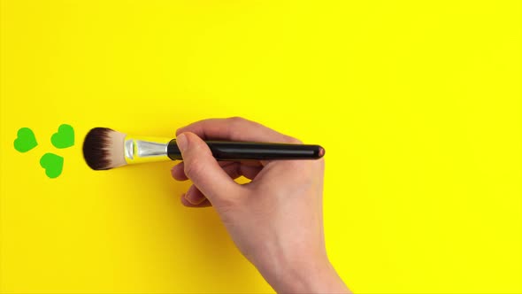 Stop motion animation of flat lay of green hearts and with paint brush in hand alt