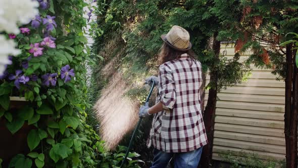 Woman Watering Plants in Garden