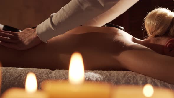 Young, healthy and beautiful woman gets massage therapy in the spa salon.