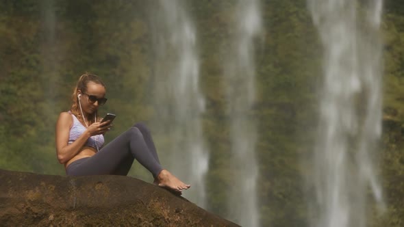 Blond Lady Sits Barefoot on Rock Listens To Music