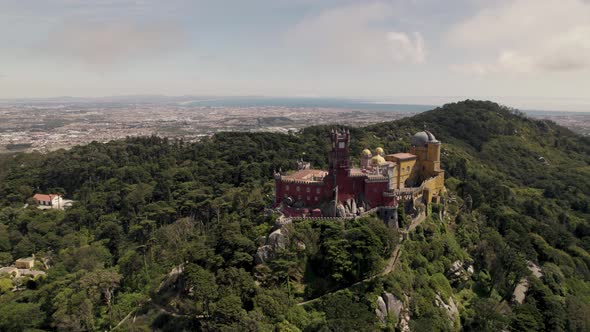 Pena Palace, hilltop castle surrounded by lush forest in Sintra, Lisbon, Portugal. Orbiting shot.